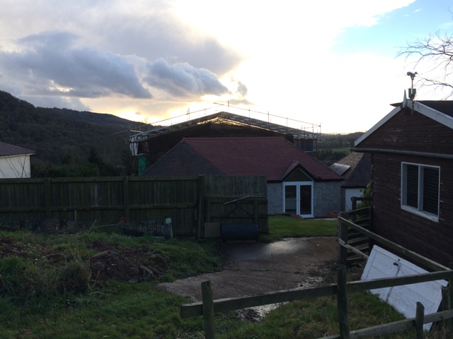 view-of-back-of-house-new-kitchen-and-canopy-visible-over-the-top-of-main-house