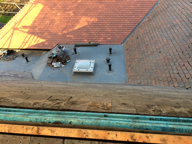 The three sloping roofs converging on the flat roof of the utility room